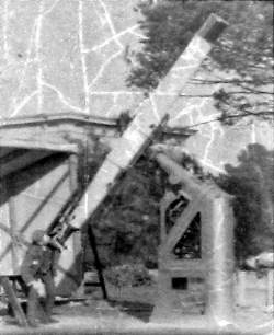 Man looking up telescope which is outdoors