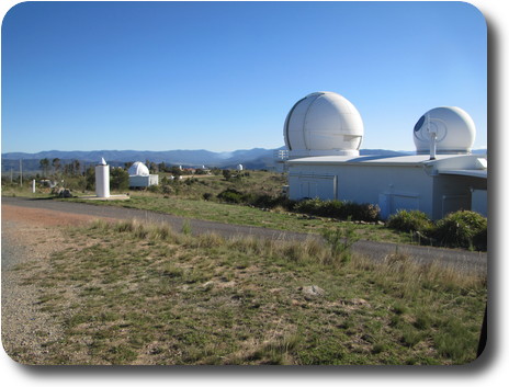 Low building with 2 domes on top; other telescope domes in distance