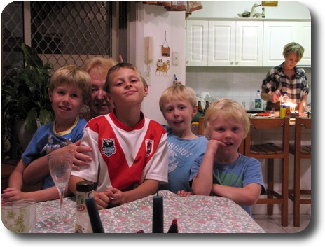 Four boys in front of grandmother at end of table