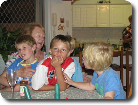 Four boys in front of grandmother at end of table