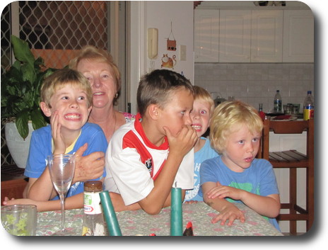 Four boys in front of grandmother at end of table