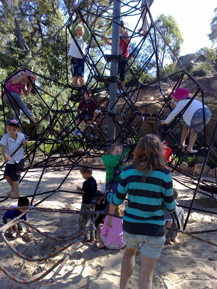 Metal pole with ropes and many children climbing them