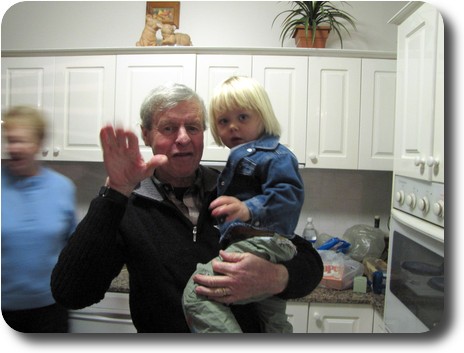 Grandfather holding granddaughter in the kitchen