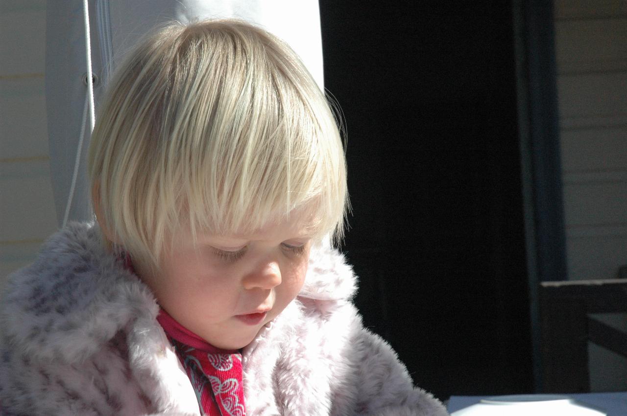 Little girl with blond hair and white coat