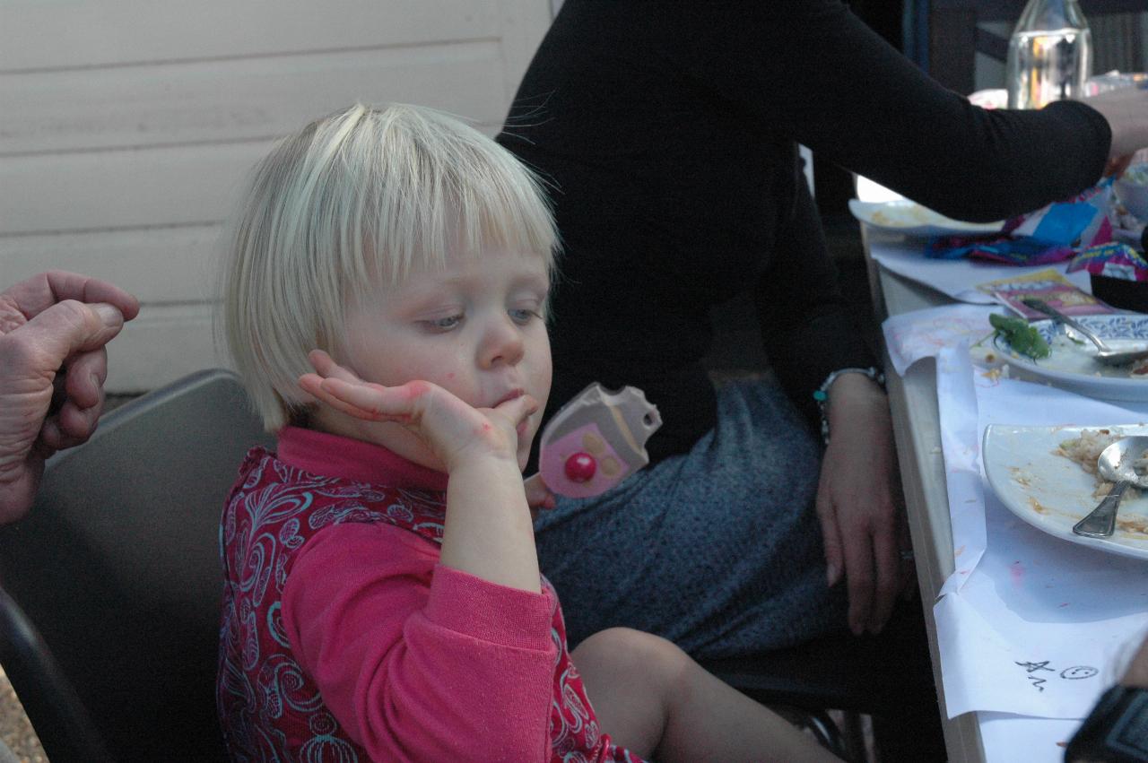 Little girl holding paddle pop and licking her fingers