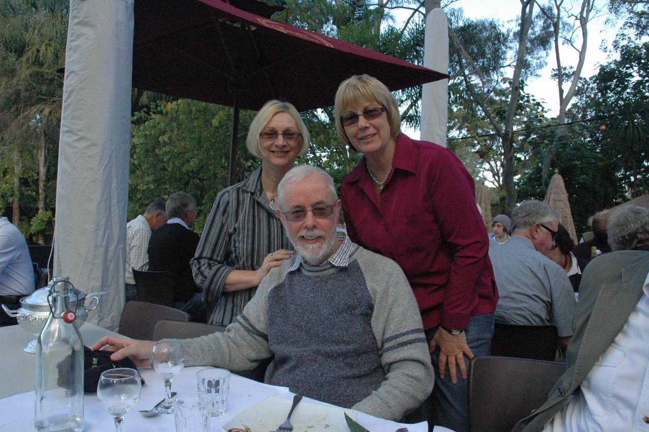 Man sitting with two women behind