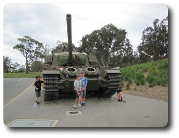 Two little boys standing in front of tank - outdoors