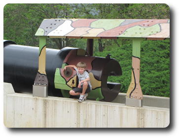 Little boy at end of very large gun barrel