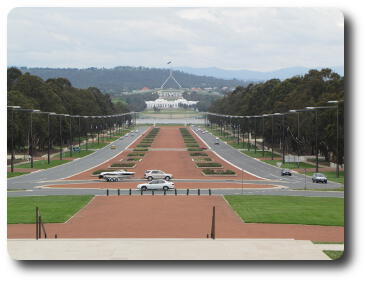 Wide street running down to lake, white building across lake