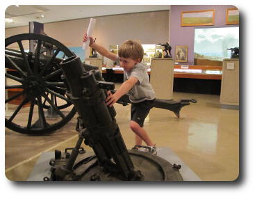 Little boy with rolled up paper in one hand at mortar