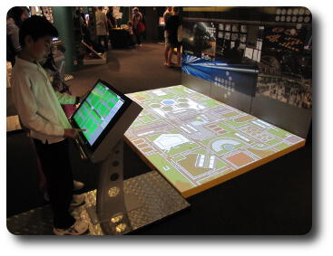 Person at display console in front of street map projected onto floor