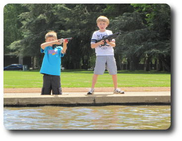 Two boys with rifles standing on parapet