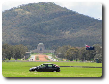 Over lawn to wide street, War Memorial and mountain behind.