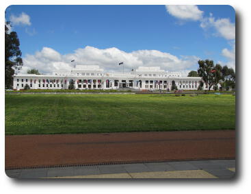 Long, white 2 storey building across lawn