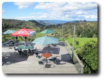 Distant hills seen beyong balcony with tables and umbrellas