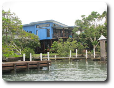 Two storey blue house on river bank