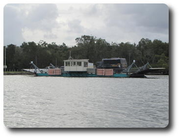 Small ferry carrying cars and a truck across river