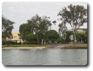 Boat launching ramp among trees and apartment buildings