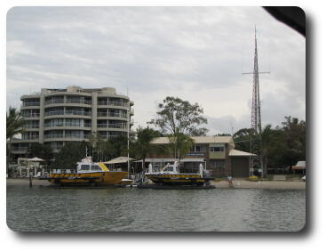 Two storey brick building with radio tower on river's edge