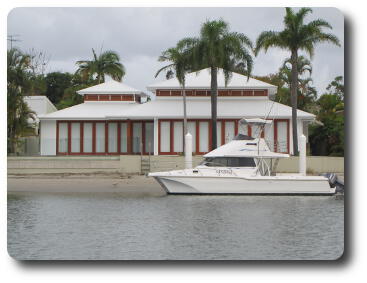 Closed up expensive, waterfront home with cruiser in front