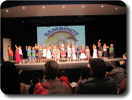 About 25 children in a line across the stage