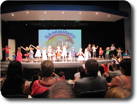 About 25 children in a line across the stage