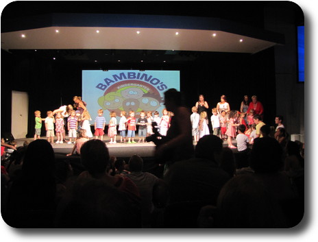 About 25 children and 5 adults on stage