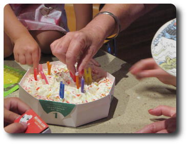 Birthday cake having candles inserted.