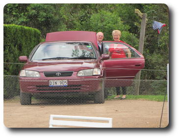 Couple at rear of car unloading items