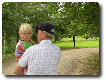 Man carrying little girl up the road