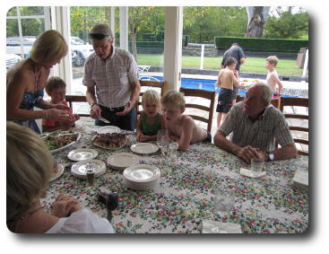 People around table, awaiting birthday cake