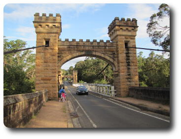 Suspension bridge with car crossing, and pedestrian walking on side of road