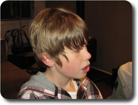 Boy with longish hair intently listening to conversation