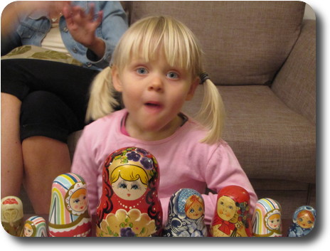 Little girl, blonde hair and blue eyes, with Russian dolls