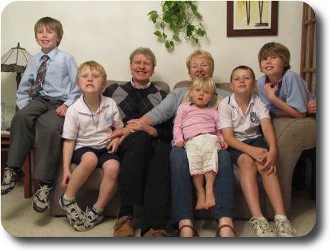 Grand parents and grandchildren sitting on lounge/sofa