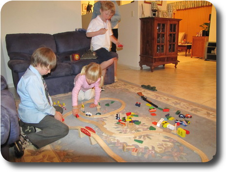 Children playing with wooden train set on the floor