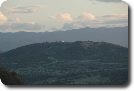 Distant hill with telescopes on top; mountains behind