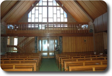 The rear of the church, showing the choir loft and stained glass window