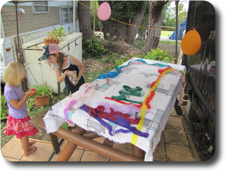 Two little girls next to picnic table, placing streamers on the table