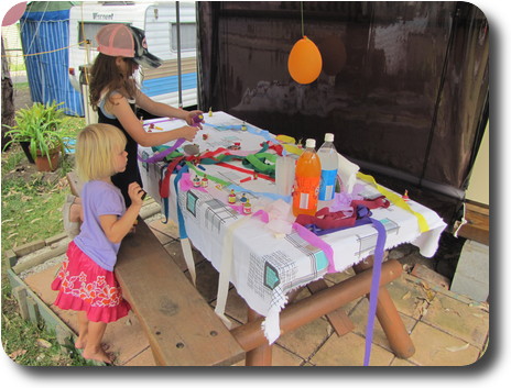 Two girls decorating table with streamers and poppers