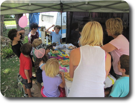 Table full of party food; children and adults singing 