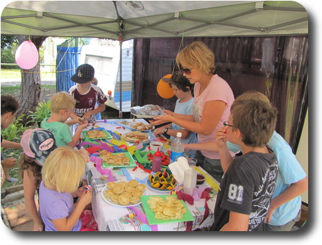 Children around table eating party food