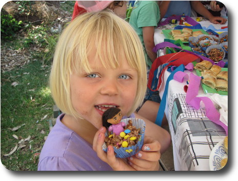 Little girl holding choclate crackle with doll on top