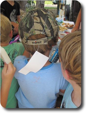 Back of boy's head, wearing a baseball cap, with the tag still on