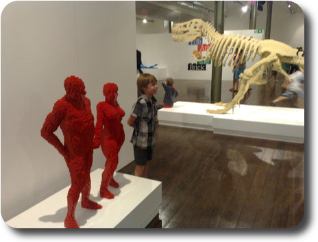 Boy standing near 2 Lego figures of his height