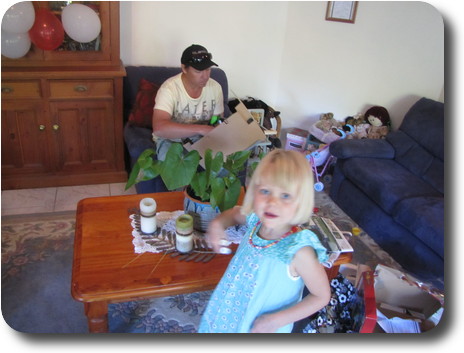 Blurred little girl in front, man sitting behind coffee table with well packaged RC quad bike