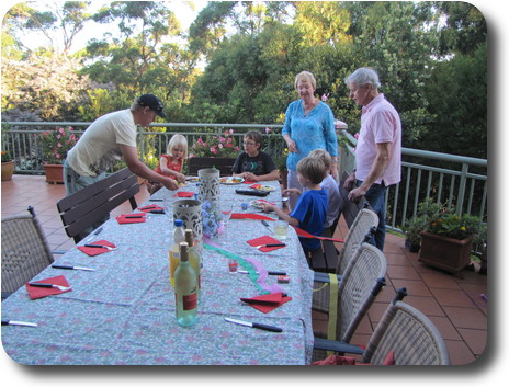 Four youngsters at far end of table, and 3 adults standing around