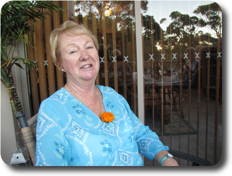 Lady in blue dress with orange flower tucked in