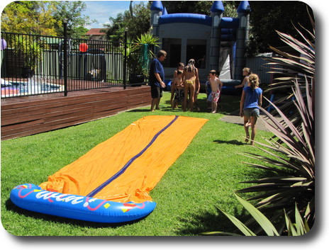 Yellow plastic slide placed on lawn for youngsters to slide along