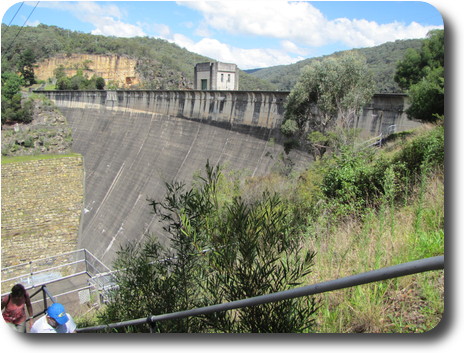 Concrete dam wall, curved, with cement block building in the middle